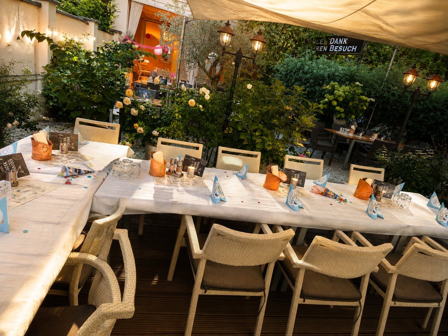 Festlich gedeckte Tafel im Sommergarten am Abend